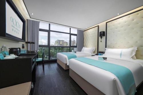 a hotel room with two beds and a window at Xana Hotelle Shenzheng South Station Foxconn in Shenzhen