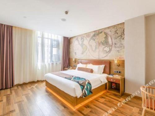 a hotel room with a bed and a painting on the wall at James Joyce Coffetel Luoyang Longmen High-speed Railway Station Baolong Plaza in Luoyang