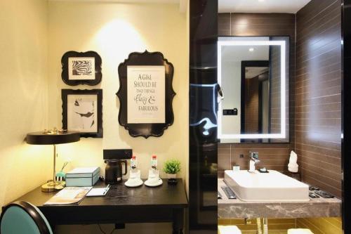 a bathroom with a sink and a mirror at Xana Hotelle Shenzheng South Station Foxconn in Shenzhen