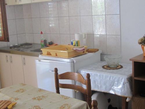 a kitchen with a stove and a table and a table and a chair at Jagoda Apartments in Zaostrog