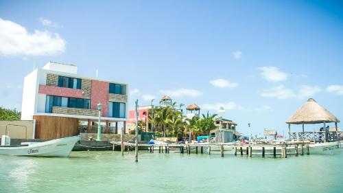 a dock with boats in the water next to a building at Yuum Ha Boutique Hotel in Río Lagartos