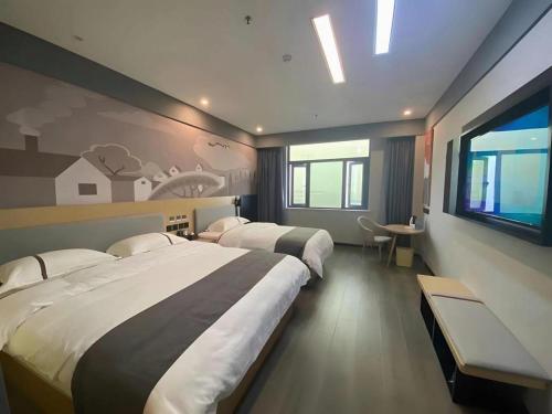 a hotel room with two beds and a tv at Thank Inn Jiangxi Nanchang Anyi County Fenghuangshan Industrial Park in Nanchang