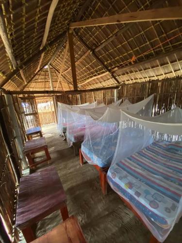 a room with a group of beds in a hut at Traditional Cabin on Aroma Island in Panama City