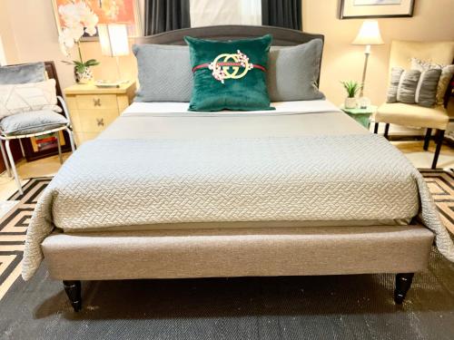 a large bed with a green pillow on it at Grande Lux Room- Boutique Hotel Style-15mins to NYC in Englewood