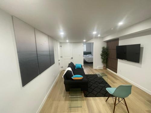 a living room with a couch and a flat screen tv at Your Cozy Happy Place in Calgary