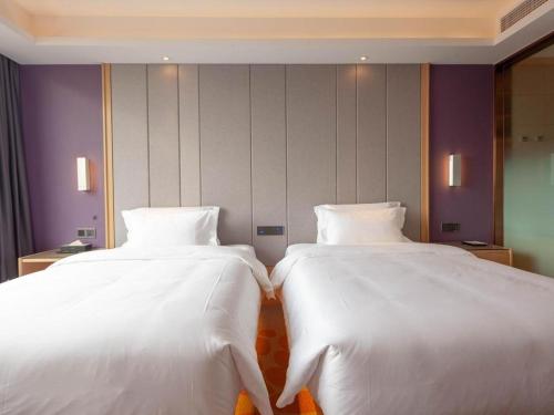 two beds sitting next to each other in a room at Lavande Hotel Changsha South High-speed Railway Station Xiyingmen in Changsha