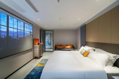 a bedroom with a large bed and a large window at Premier City Comfort Hotel Suizhou Wuyue Plaza in Suizhou