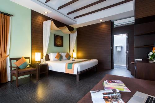 a hotel room with a bed and a desk with a desk at Baan Chaweng Beach Resort & Spa - SHA Extra Plus in Chaweng