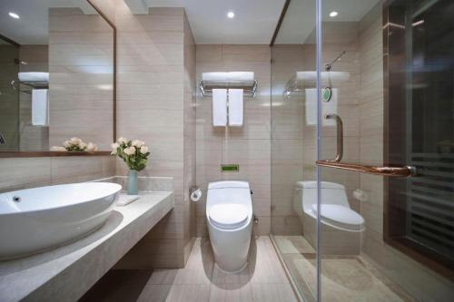 a bathroom with a sink and a toilet and a shower at Vienna Hotel Shandong Liaocheng High-Tech Zong Yueji Park in Liaocheng