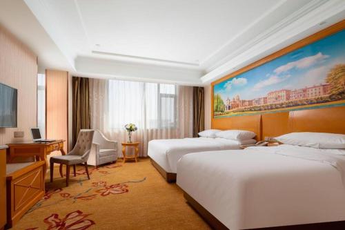 a hotel room with two beds and a desk at Vienna Hotel Tianjin 5th Avenue Youyi Road Cultural Center Metro Station in Tianjin