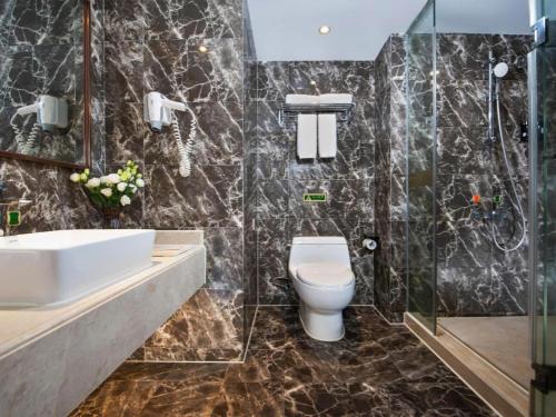a bathroom with a toilet and a sink and a shower at Venus International Hotel Guangdong Huizhou West Lake in Huizhou