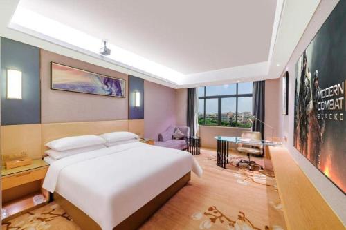 a bedroom with a large white bed and a large window at Vienna Hotel Guangdong Zhongshan Xiaolan High-Speed Railway Station in Zhongshan
