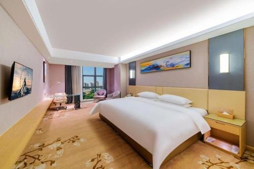 a large bedroom with a large white bed in it at Vienna Hotel Guangdong Zhongshan Xiaolan High-Speed Railway Station in Zhongshan