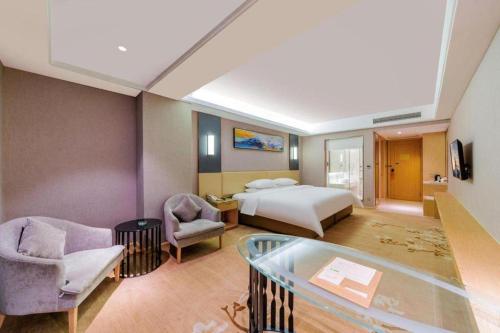 a hotel room with a bed and a glass floor at Vienna Hotel Guangdong Zhongshan Xiaolan High-Speed Railway Station in Zhongshan