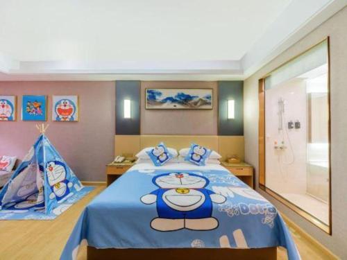 a bedroom with a large bed with a blue blanket at Vienna Hotel Guangdong Zhongshan Xiaolan High-Speed Railway Station in Zhongshan