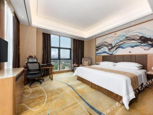 a hotel room with a large bed and a television at Venus Royal Hotel Nanning East High-Speed Railway Station in Nanning