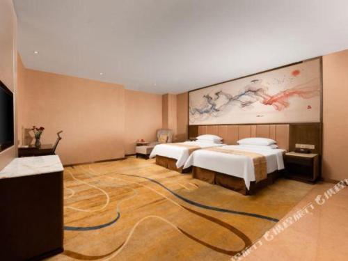 a hotel room with two beds and a painting on the wall at Venus Royal Hotel Nanning East High-Speed Railway Station in Nanning