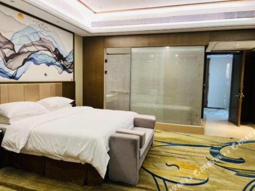 a bedroom with a large bed and a window at Venus Royal Hotel Nanning East High-Speed Railway Station in Nanning