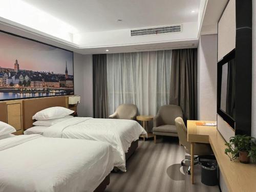 a hotel room with two beds and a flat screen tv at Vienna Hotel Jiangxi Shangrao High-Speed Railway Station in Shangrao
