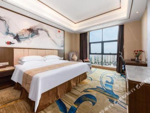 a bedroom with a large bed and a large window at Venus Royal Hotel Nanning East High-Speed Railway Station in Nanning