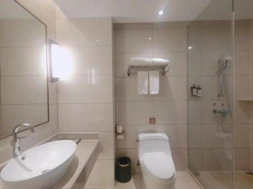 a bathroom with a sink and a toilet and a shower at Vienna Hotel Jiangxi Fengcheng Fnegkuang in Fengcheng