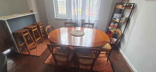 Una mesa y sillas de madera en una habitación con ventana. en AT Home, en Burgas