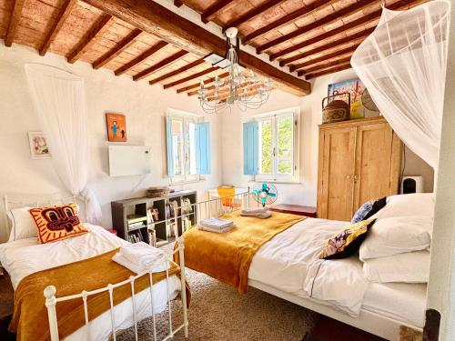 sypialnia z 2 łóżkami i żyrandolem w obiekcie Magical villa, breathtaking views, large private garden and olive grove - in a cool village on the Umbria Tuscany Border w mieście Gioiella