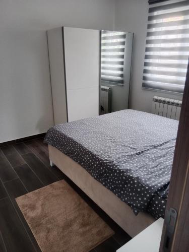 a bedroom with a bed and two windows at Nuko's family in Nikšić