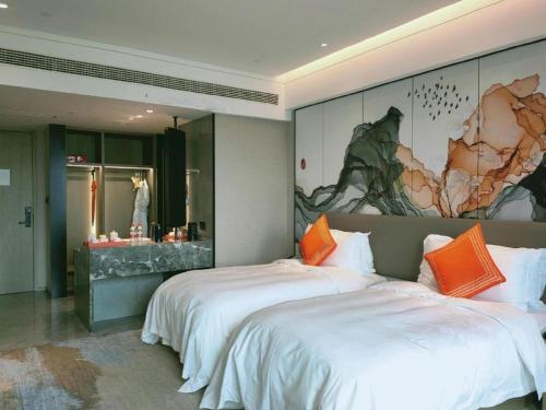 une chambre avec deux lits et un tableau au mur dans l'établissement Yinhu Junyi Hotel（Wildlife Park）, à Hangzhou