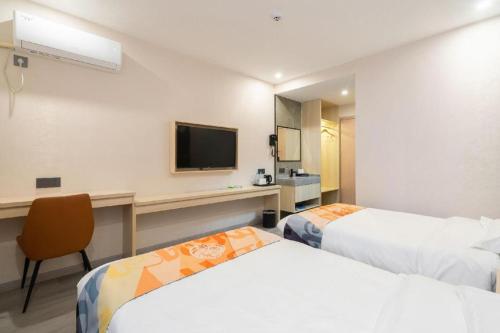 a hotel room with two beds and a desk at Shell Hotel Wuxi Huishan District Chang'an Town in Wuxi