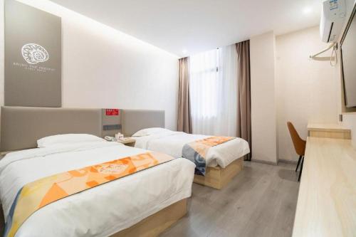 a hotel room with two beds and a television at Shell Hotel Wuxi Huishan District Chang'an Town in Wuxi