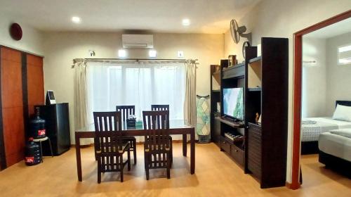 a living room with a table and chairs and a television at Ciput's Den in Bandung