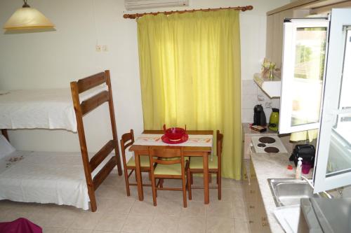 a room with a table and chairs and a bed at Villa Romantza in Fiskardho