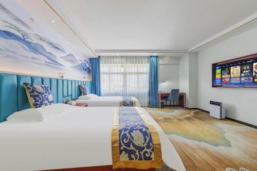 a hotel room with two beds and a desk at Yue Lai Yue Hotel in Guangzhou