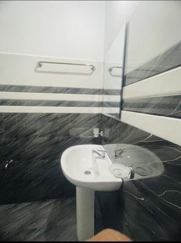 a bathroom with a white sink and a mirror at Vegetable Garden House in Adams Peak