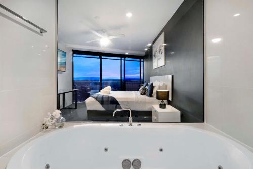 une salle de bain avec baignoire et une chambre avec un lit dans l'établissement Circle on Cavill - 2 Bedroom Converted Apartments - Wow Stay - No Parking Included, à Gold Coast