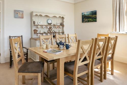 a dining room with a wooden table and chairs at Wetherlam in Ambleside