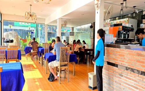 a group of people sitting at tables in a restaurant at Blossoming Romduol Boutique in Siem Reap
