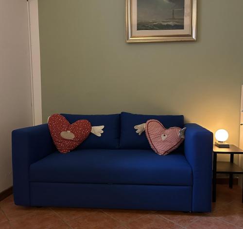 a blue couch with two heart pillows on it at Casamanu in Montebelluna