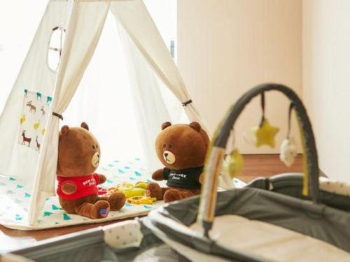 two teddy bears sitting on top of a bed at Xiamen Seashine Lakeview Hotel in Xiamen