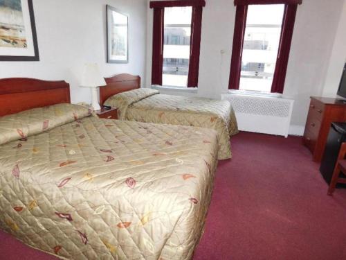 a hotel room with two beds and two windows at Hotel Harrington in Washington