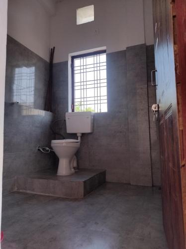 a bathroom with a toilet and a window at Raura Basera in Srīnagar