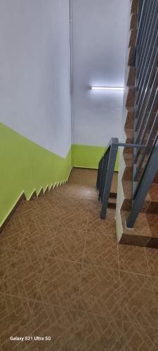 a row of benches in a room with green walls at Zahaar KN Inn in Batu Ferringhi