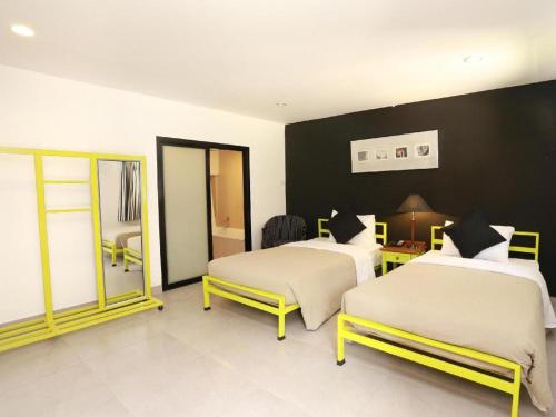 a bedroom with two beds and a black wall at MDR Hotel in Lop Buri