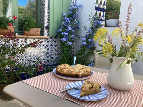 une table avec deux assiettes de nourriture et un vase avec des fleurs dans l'établissement Bergerie Balbonne, à Durban-Corbières