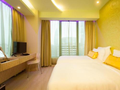a hotel room with a bed and a desk with a television at Harbour Bay Hotel in Hong Kong