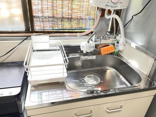 an rv kitchen with a sink and a faucet at サニーサイドホステル1号館 in Uji