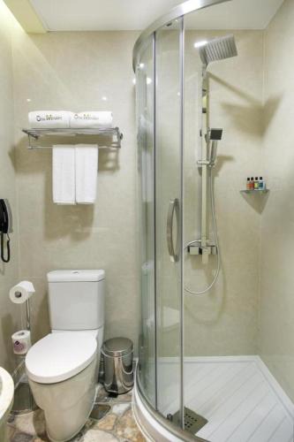 a bathroom with a toilet and a glass shower at Harbour Bay Hotel in Hong Kong