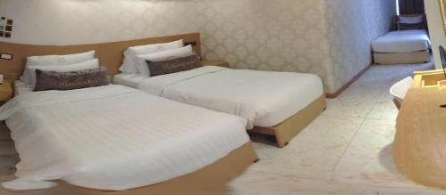a hotel room with two beds and a sink at Harbour Bay Hotel in Hong Kong
