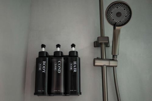a shelf with three black bottles next to a fan at Harbour Bay Hotel in Hong Kong